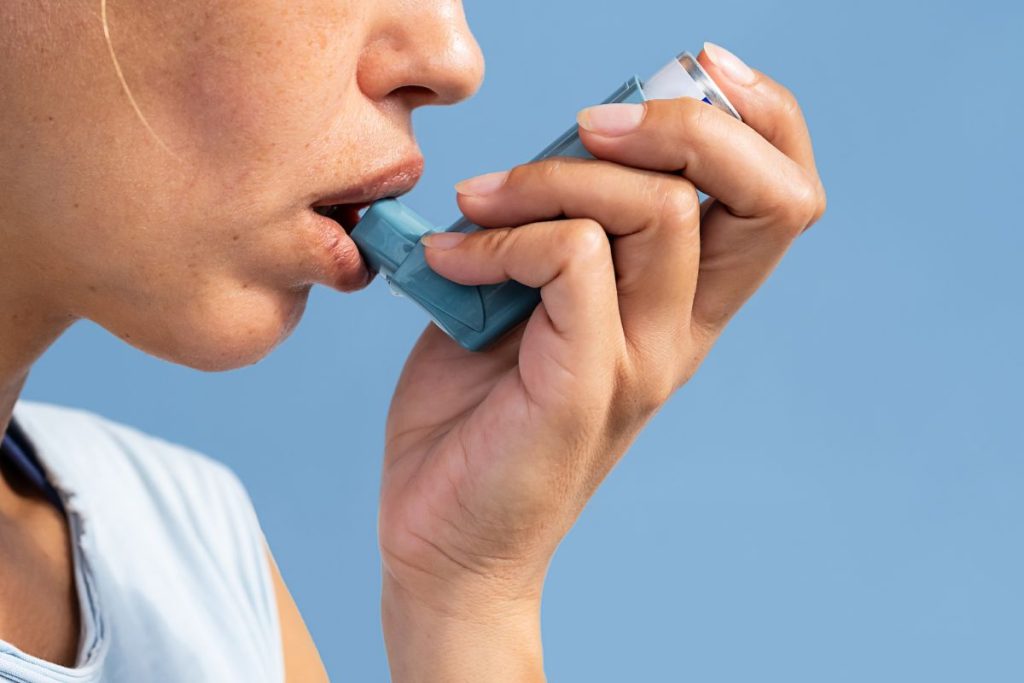 Woman using asthma inhaler